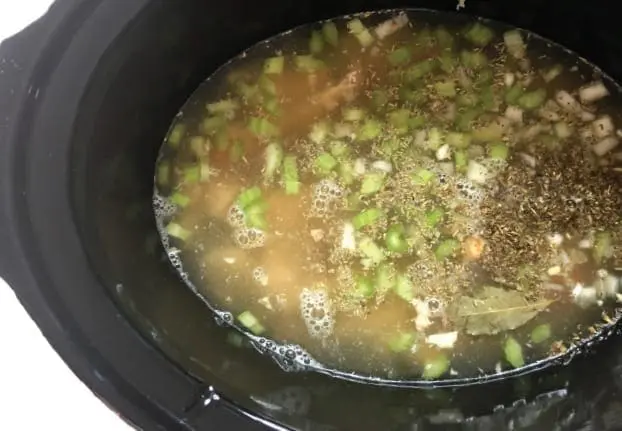 Chicken noodle soup ingredients in a slow cooker.
