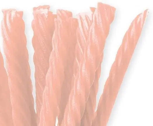 Faded red licorice candy sticks standing upright.
