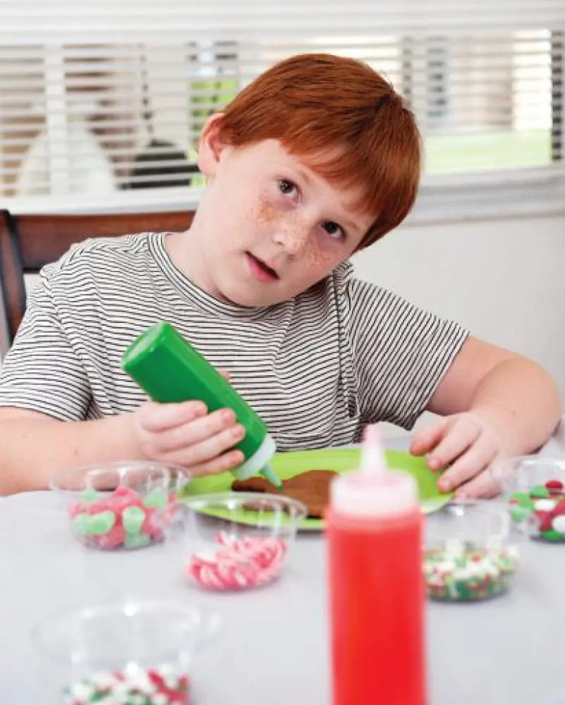 Ayden McCann decorating a cookie with green icing.
