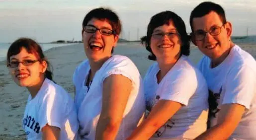 PJ Nein and three children on a beach.