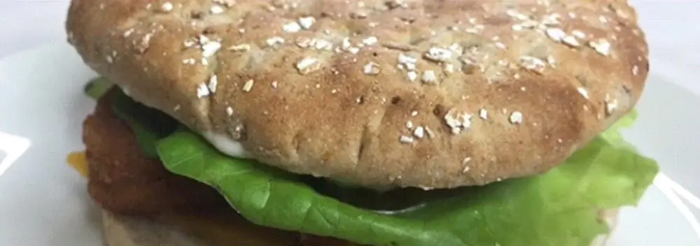 Vegan chicken nugget sandwich with lettuce on a whole wheat bun.