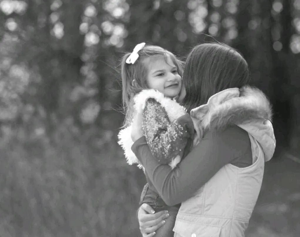 Finley hugs Kimberly outdoors.