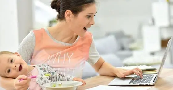 Woman multitasking with a baby at a laptop