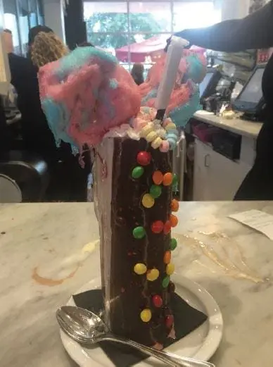 Chocolate milkshake topped with cotton candy and candies