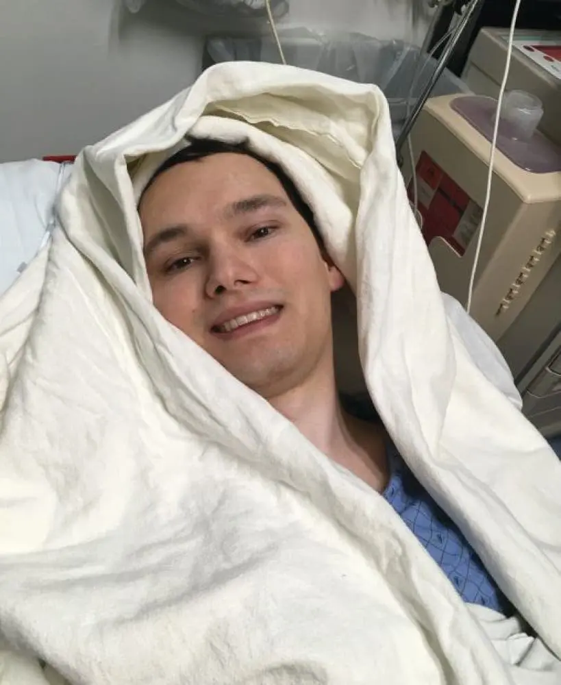 Joshua bundled in blankets in a hospital bed.