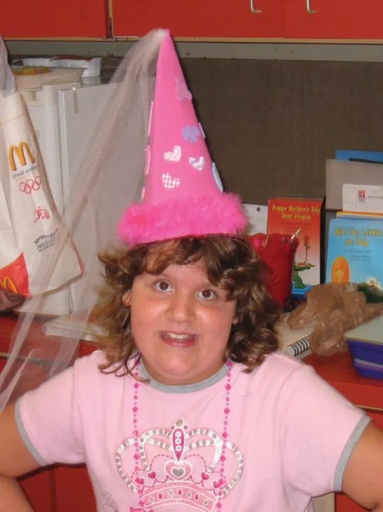 Kailee wears a pink birthday hat and shirt.