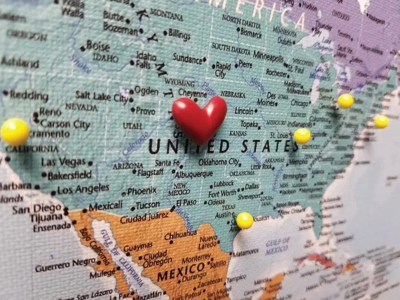 Map of the United States with a red heart pin in the center and yellow pins marking locations.