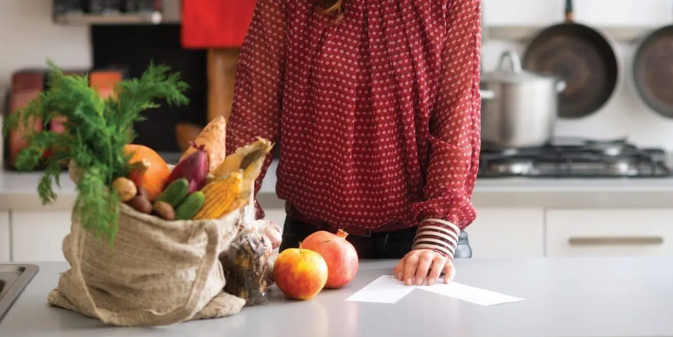Bag of fresh produce and fruit on a kitchen counter