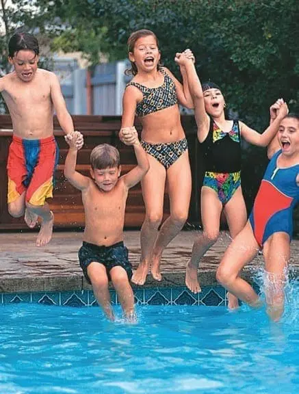 Children jumping into a swimming pool