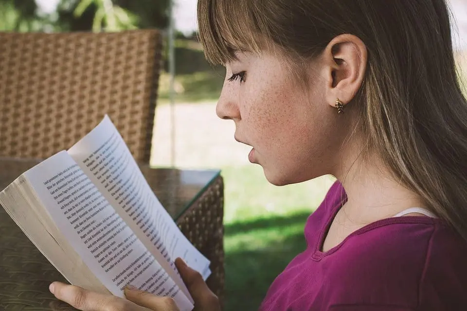 Woman reading a book outdoors.