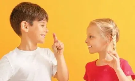 Two children interacting, with the boy pointing his finger at the girl.