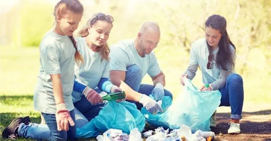 Family cleaning up litter in a park