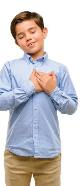 Young boy with eyes closed and hands over his heart