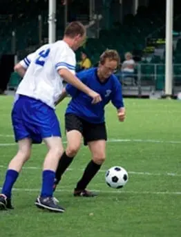 Two athletes playing soccer on a field.