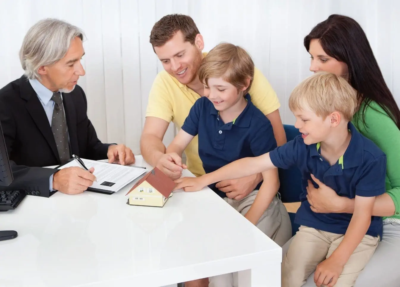 A financial planner discusses a model home with a family of four.