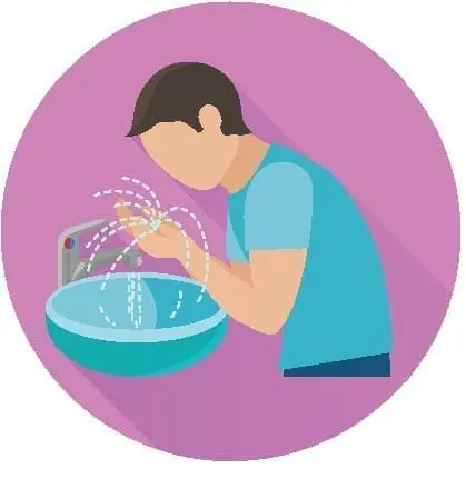 A person washing their hands at a sink.