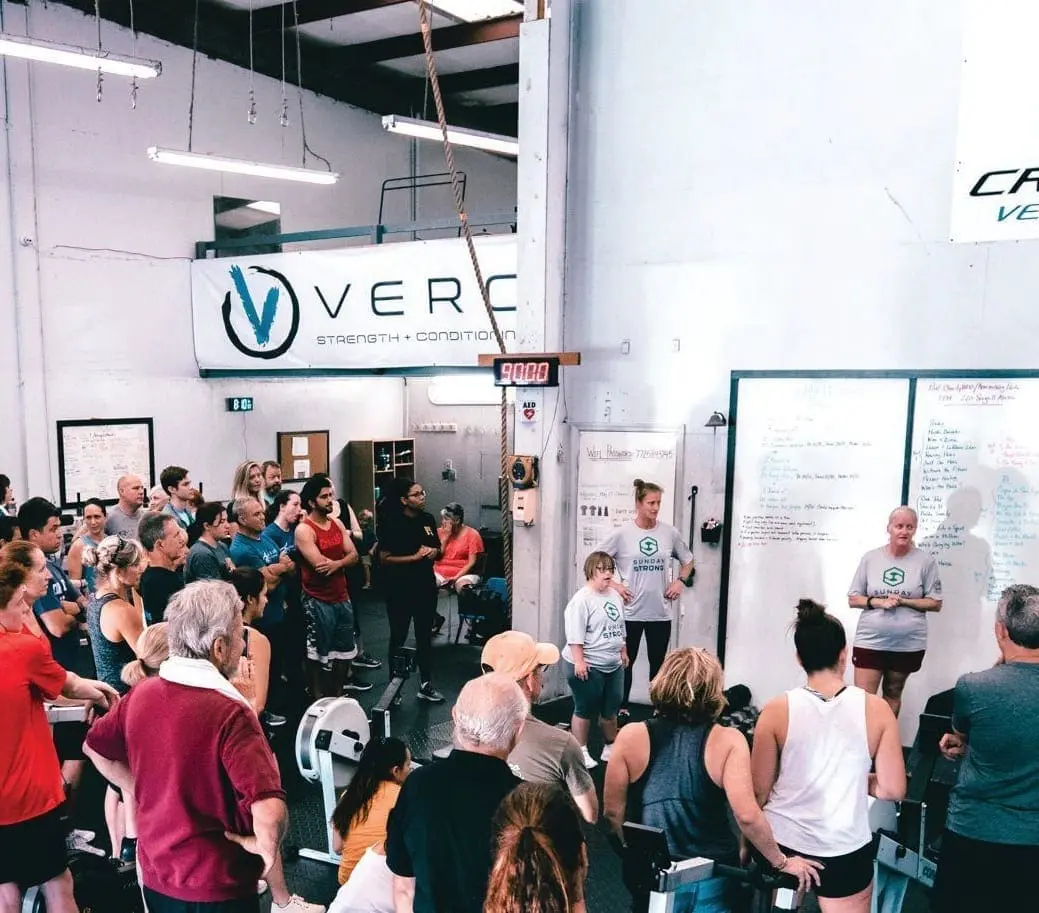 A group of adults participate in an exercise class indoors.