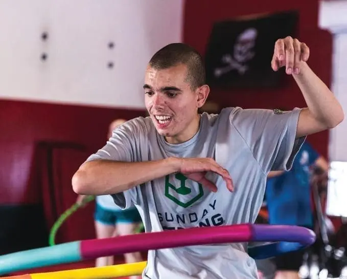 Man with intellectual disability hula hooping at a Sunday Strong event