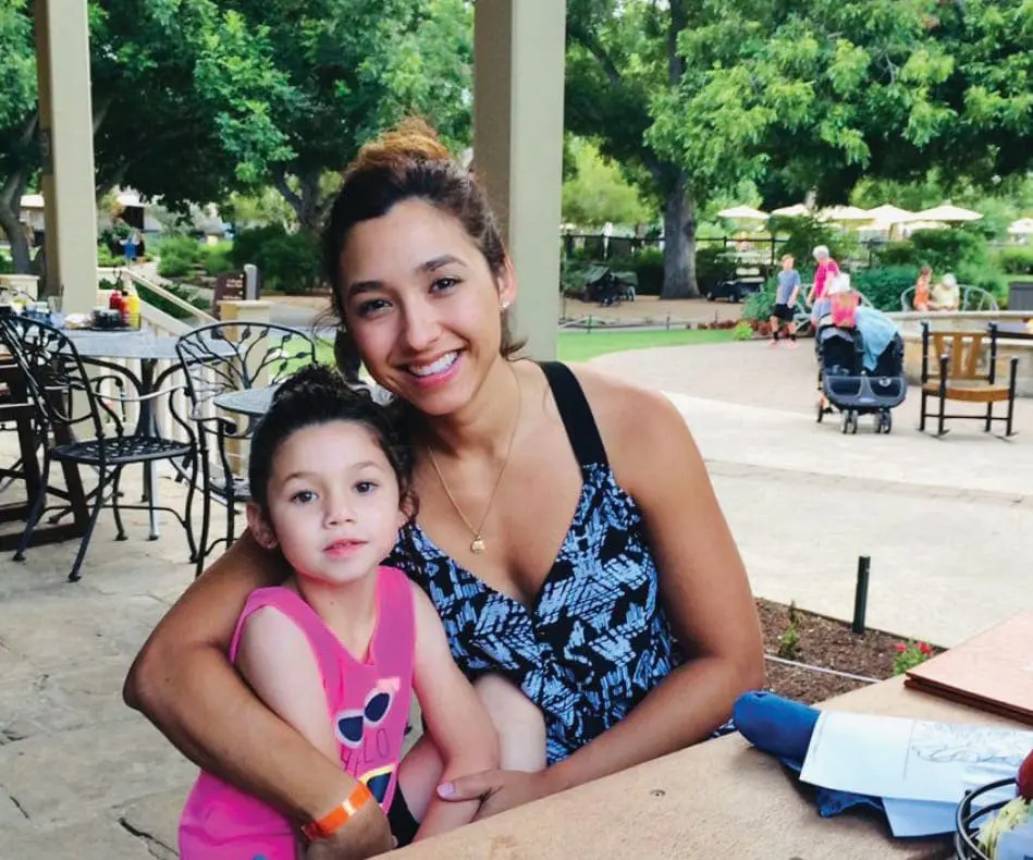 Lisa Peña with her daughter Isla outdoors at a table.