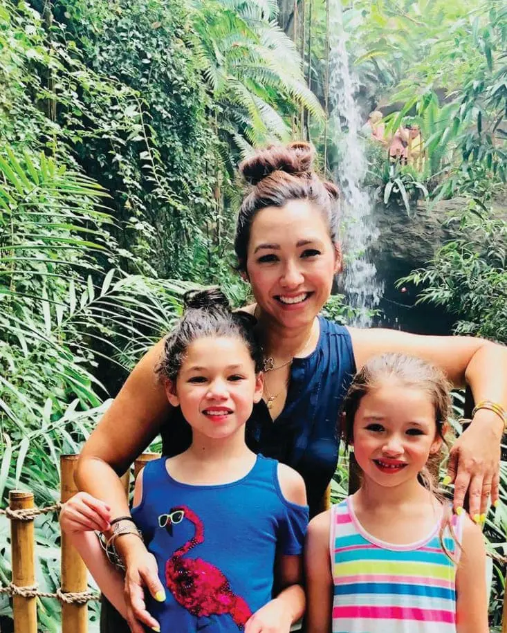 Dr. Lisa Peña with her two daughters in front of a waterfall.
