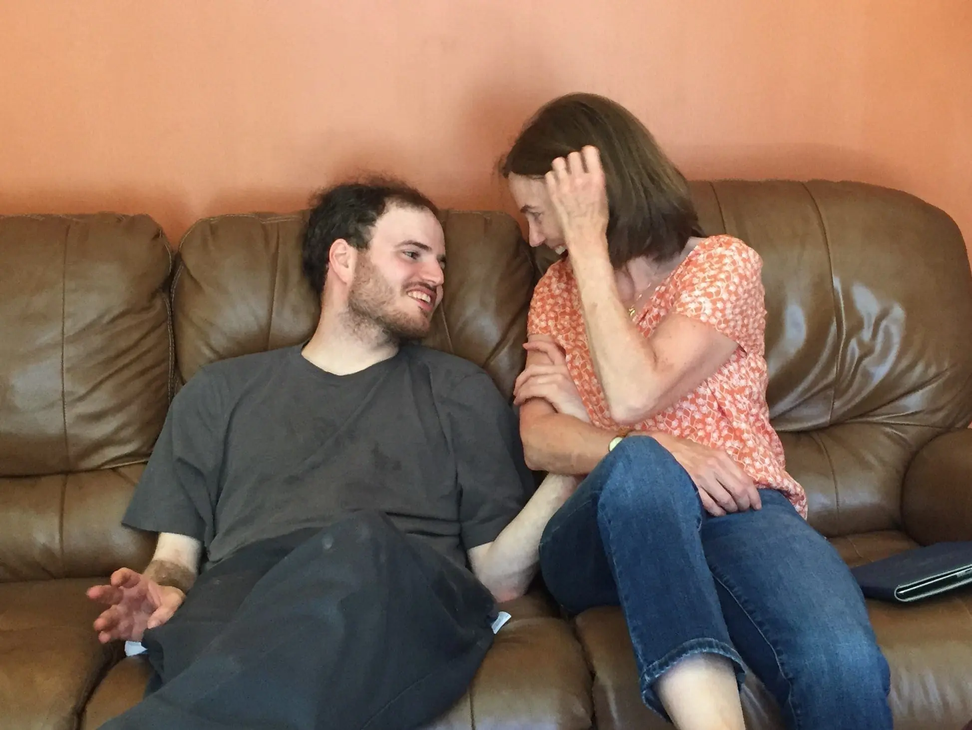 Brian and his mother talking on a couch.