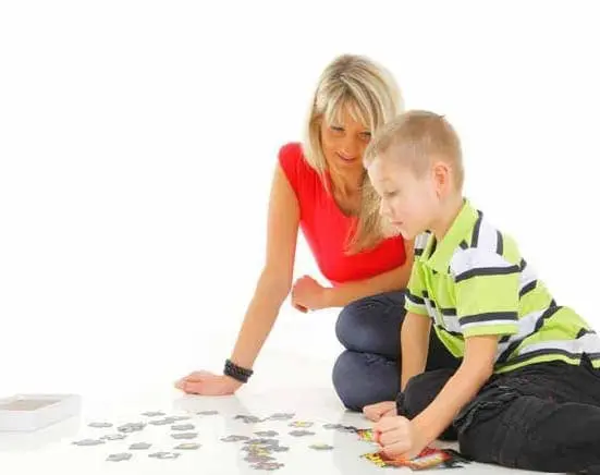 Woman and boy assembling a puzzle on the floor