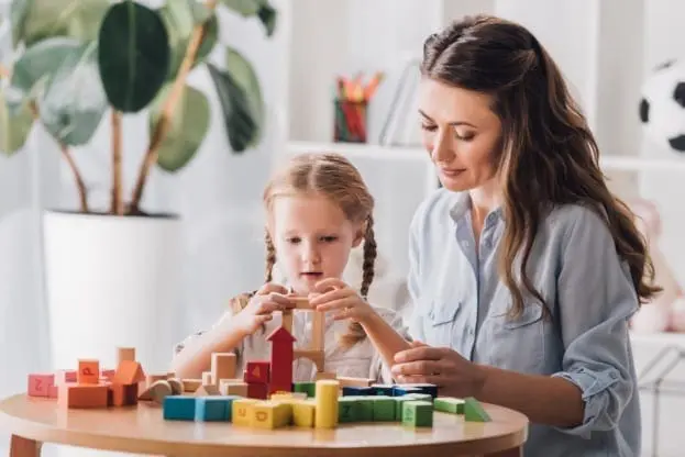 Woman and child building with blocks on a table