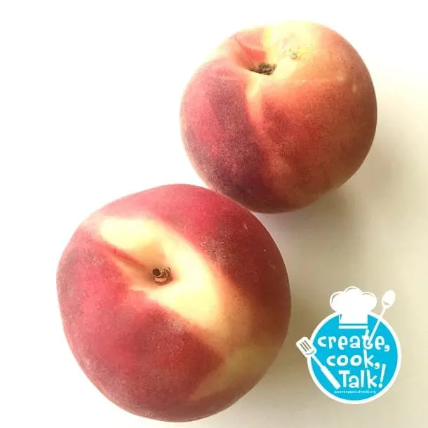 Two ripe peaches with a logo that says "create, cook, Talk!