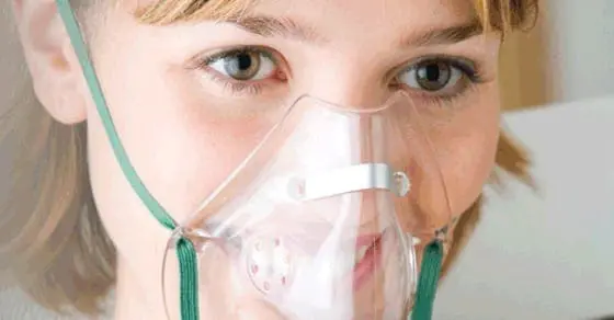 Close up of a person wearing an oxygen mask.