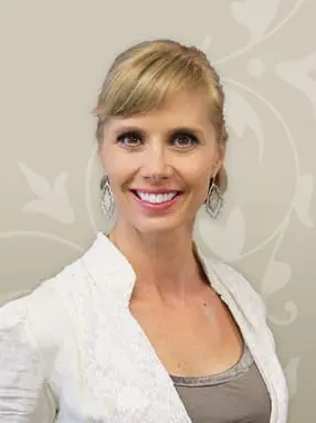 Paula Kettula smiling with decorative background.