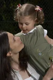 Woman looking at a young child in her arms