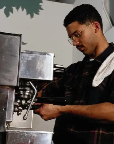 Man in glasses making coffee with an espresso machine