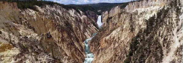 Waterfall cascading through a rocky canyon in Yellowstone National Park.
