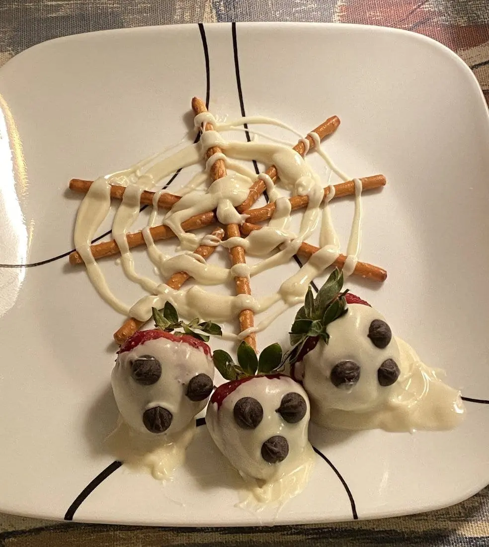 Chocolate-covered strawberries and pretzel sticks arranged on a plate.