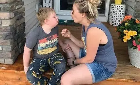 Kate Swenson and a young boy sitting on a porch.