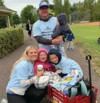 Kate Swenson and her family pose for a photo during an outdoor event.