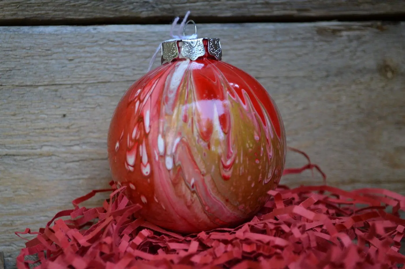 Kodie Multi-Media Art Ornament with red, white, and gold paint swirls