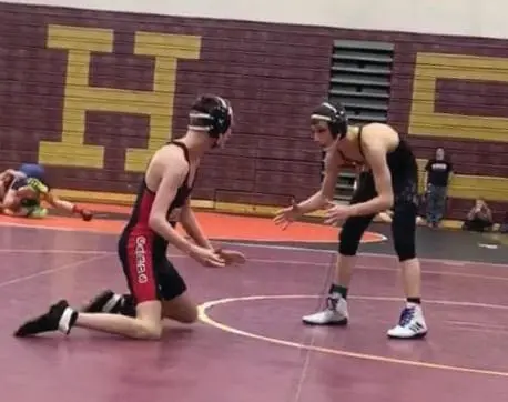 Cody wrestles on a mat in a competition.