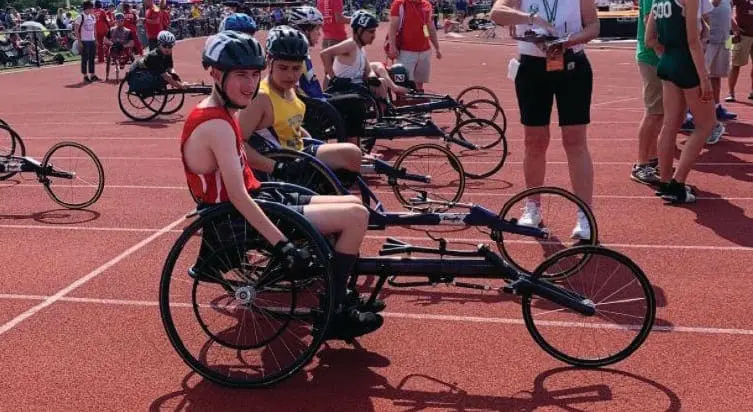 Cody and other athletes in racing wheelchairs on a track