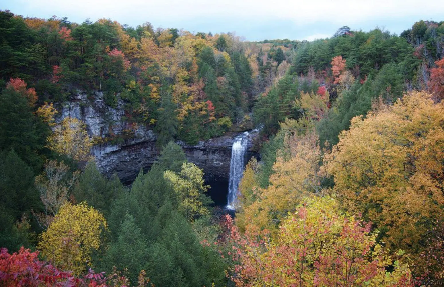 Foster Falls waterfall surrounded by colorful autumn trees.