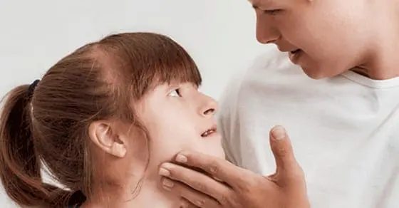 A person gently touches a child's face.