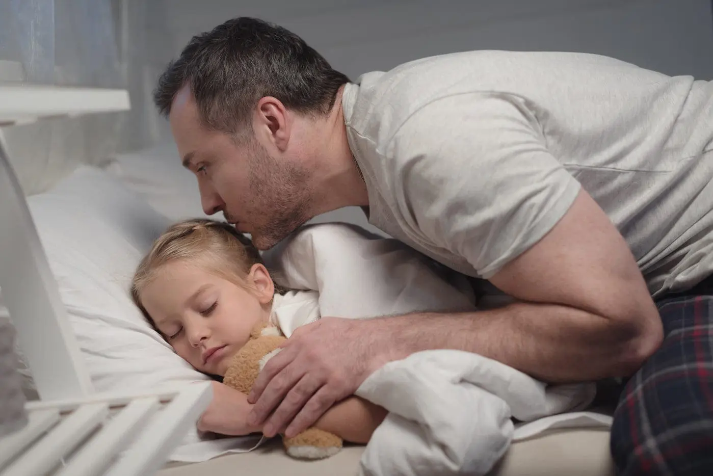 Father kissing child goodnight