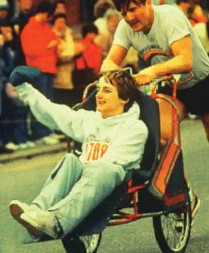 Dick Hoyt pushing his son Rick in a wheelchair during a race.