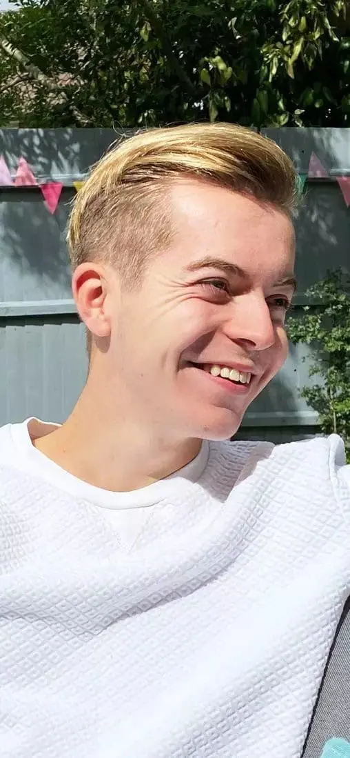 Mikey smiling outdoors.