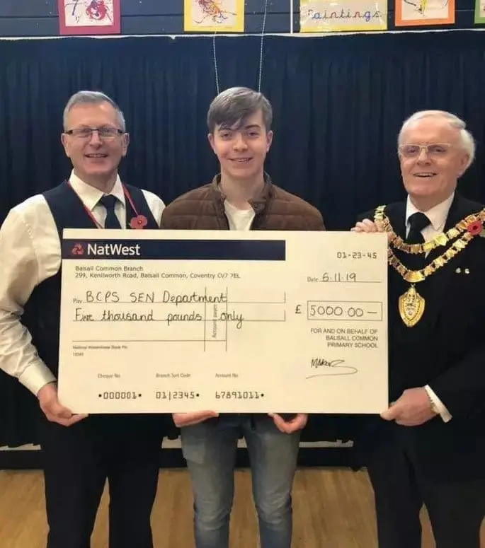 Three people hold a NatWest cheque for five thousand pounds to BSPS SEN Department.