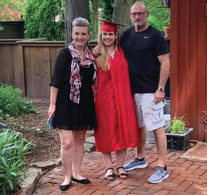 Sydney in her red cap and gown with her mother and bonus father.