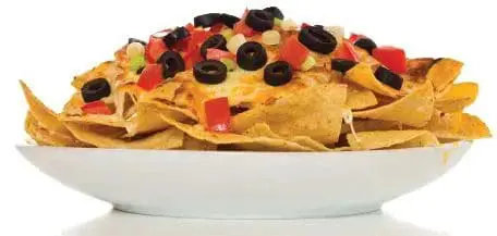 Nachos topped with cheese, olives, and diced tomatoes served in a white bowl