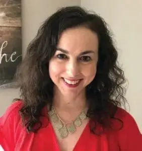 Natalie Hankins smiling with a necklace and red top.