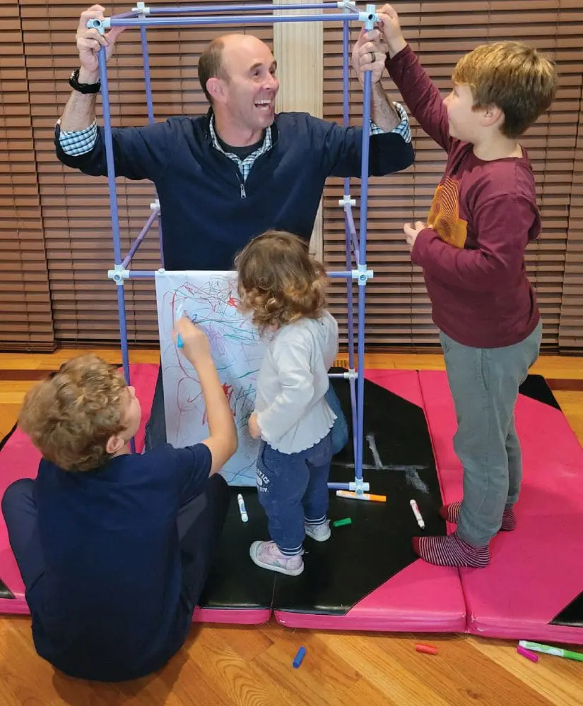 Greg Santucci builds a structure with two children.