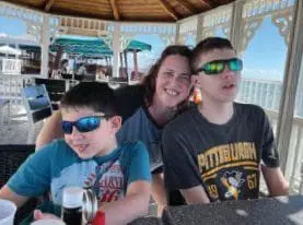 Robin Suzelis with her two sons under a gazebo.